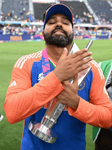 a man with a beard is holding a trophy that says india on it