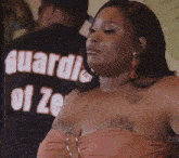 a woman is standing in front of a man wearing a shirt that says guard of ze .