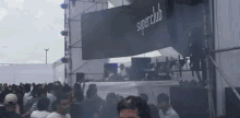 a crowd of people are gathered in front of a superclub banner