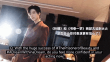 a man in a suit is standing in front of a sign that says ' the prisoner of beauty '