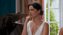 a woman in a white dress sitting in front of a piano
