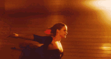 a woman is dancing in front of a fire exit sign