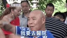 a group of people are gathered around a bald man with chinese writing on his face
