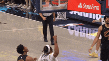 a basketball game is being played in front of a state farm ad