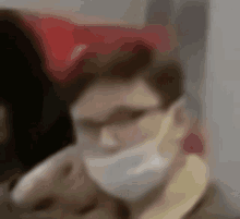 a blurry image of a man wearing a mask and glasses