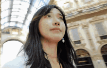 a woman with long black hair is looking up at the sky