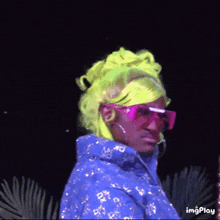 a person wearing neon green hair and pink sunglasses