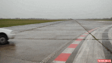 a white car is driving down a wet runway with thinkjules written on the bottom right corner
