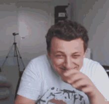 a man wearing a white t-shirt with a picture of a dog on it is laughing