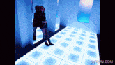 a gif from gifrun.com shows a woman standing in a dark room