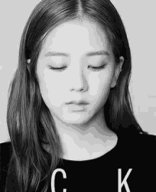 a black and white photo of a young woman with her eyes closed and a piercing in her ear .