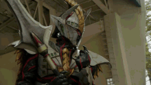 a monster with a sword and a helmet has the number 100 on his chest