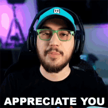 a man with a beard wearing headphones and glasses says " appreciate you "