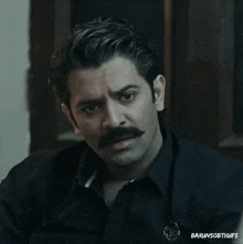 a man with a mustache is wearing a black shirt that says ' barunsobigifs ' on it