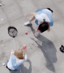 two people playing with a ball on a concrete surface