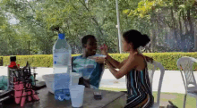 a woman is feeding a man a plate of food while sitting at a table .
