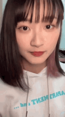 a close up of a woman 's face wearing a hoodie that says ' t3m ' on it