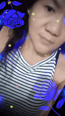a woman in a striped tank top is taking a selfie with flowers and stars on her face