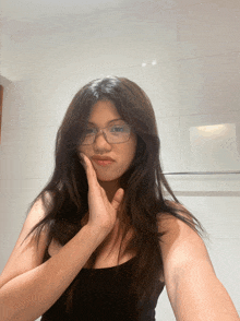 a woman wearing glasses is taking a selfie