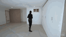 a woman is walking through an empty room with the words made in animatica on the bottom right