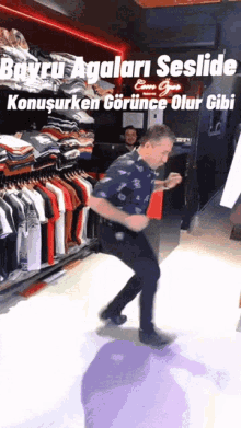 a man is dancing in front of a display of shirts and a sign that says " buyru agalari seslid "