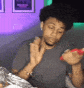 a man is sitting at a table eating a hamburger .