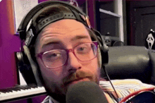 a man wearing glasses and headphones is talking into a microphone
