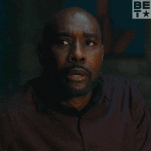 a man 's face is shown with a be t logo behind him