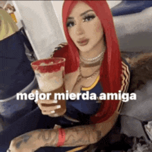 a woman with red hair is holding a drink that says mejor mierda amiga on it