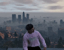 a man wearing a pink sweater with the word no on it stands in front of a city