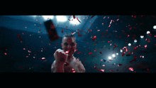 a man in a boxing ring with confetti falling on him