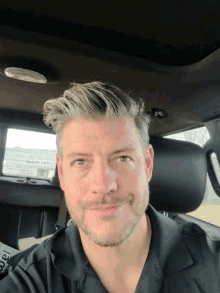 a man in a black shirt is sitting in the back seat of a car looking up