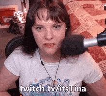 a woman sitting in front of a microphone with the words twitch.tvitstina written on the bottom