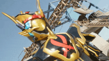 a man in a black and gold costume with a red x on the chest