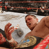 a man in a wrestling ring with a belt that says world heavyweight champion on it