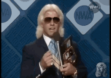a man in a suit and tie is holding a microphone and a book