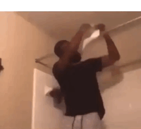 a man is hanging upside down on a ceiling bar .
