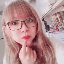 a woman wearing glasses is making a funny face