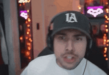 a man wearing a hat and headphones is looking at the camera .