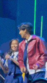 a man and a woman are standing next to each other on a stage .
