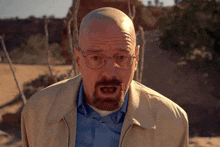a bald man with a beard and glasses is making a funny face .