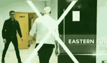 two men are standing in front of a sign that says eastern euro .