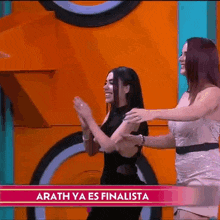 two women are dancing on a stage in front of a sign that says arath ya es finalista