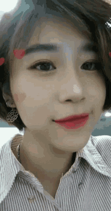 a close up of a woman wearing a striped shirt