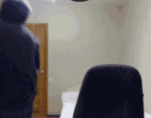 a blurry picture of a man in a hoodie standing in a room