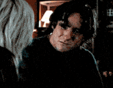 a man in a black shirt is looking at a woman