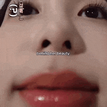 a close up of a woman 's face with red lips and the words `` behind her beauty '' written on it .