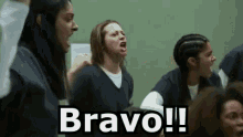 a group of women are screaming in a prison cell with the words `` bravo ! '' written above them .