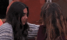 two women with long hair are looking at each other