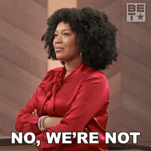 a woman in a red shirt with her arms crossed says " no we 're not "